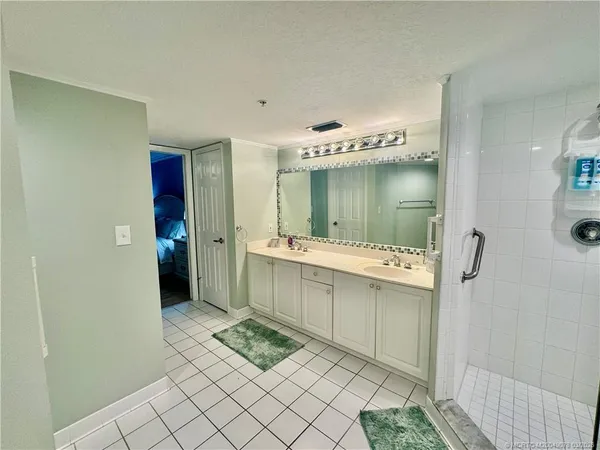 a bathroom with a sink mirror and a shower