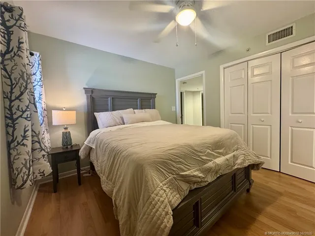a bed sitting in a bedroom next to a lamp and a chandelier