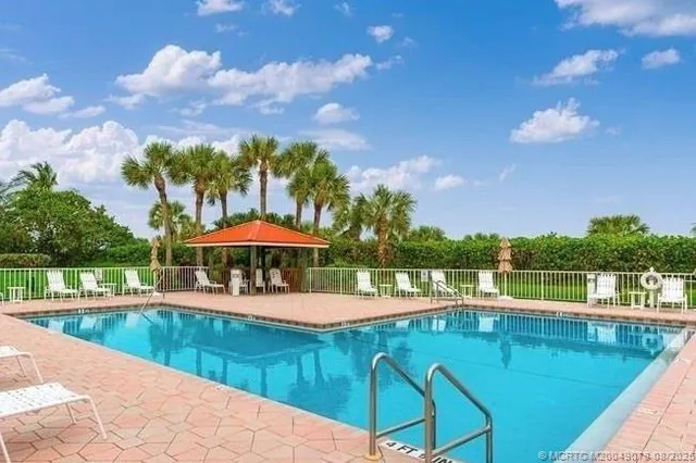 a view of a swimming pool with a patio and a yard