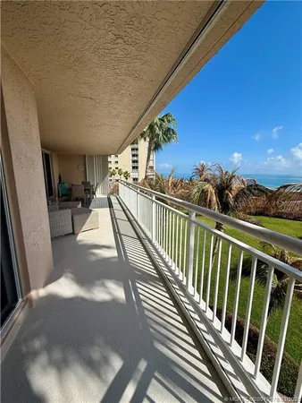 a view of balcony with wooden floor and fence