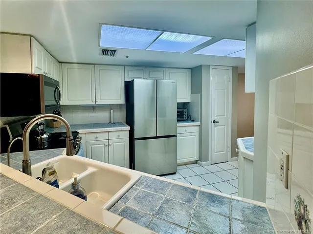 a kitchen with a refrigerator sink and cabinets