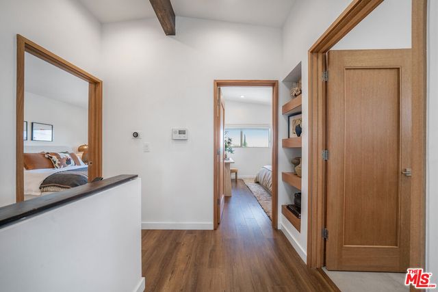 a view of a hallway with wooden floor and a living room
