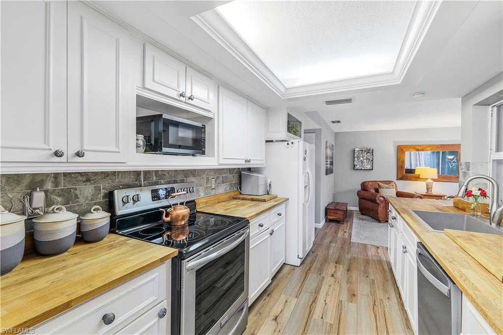 660 Pompano Drive Naples, FL 34110 - Photo 14 of 34 a kitchen with a stove a sink and a refrigerator