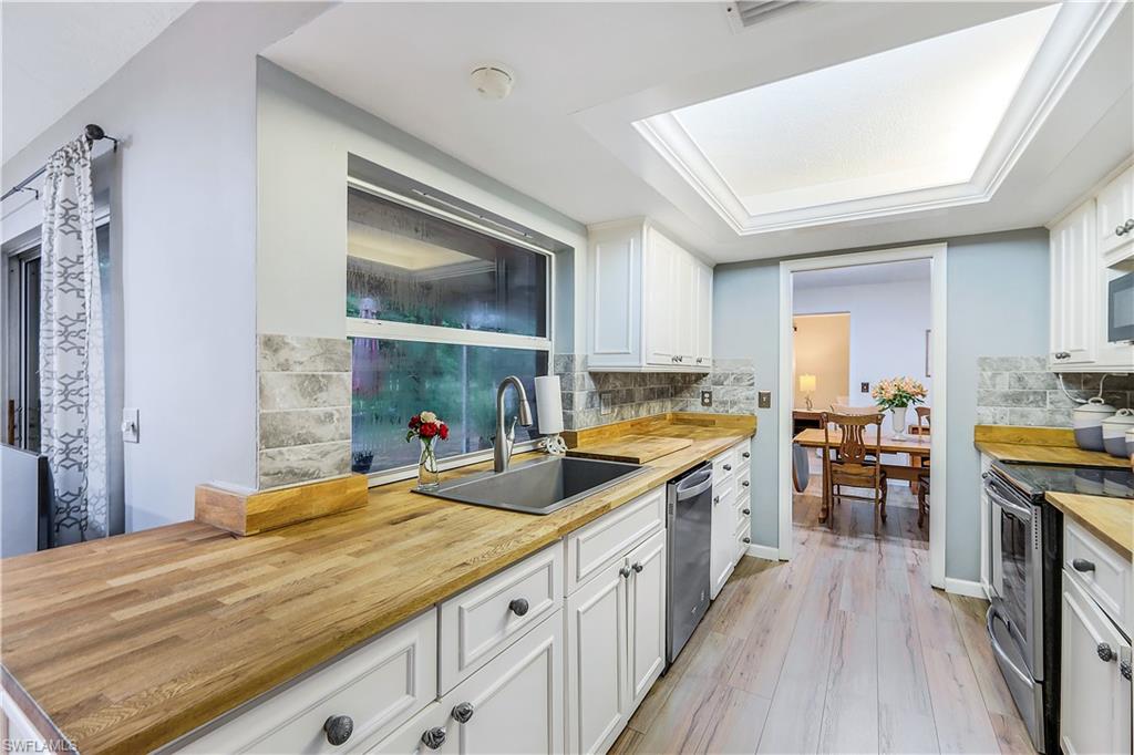 660 Pompano Drive Naples, FL 34110 - Photo 15 of 34 a kitchen with counter top space a sink and appliances