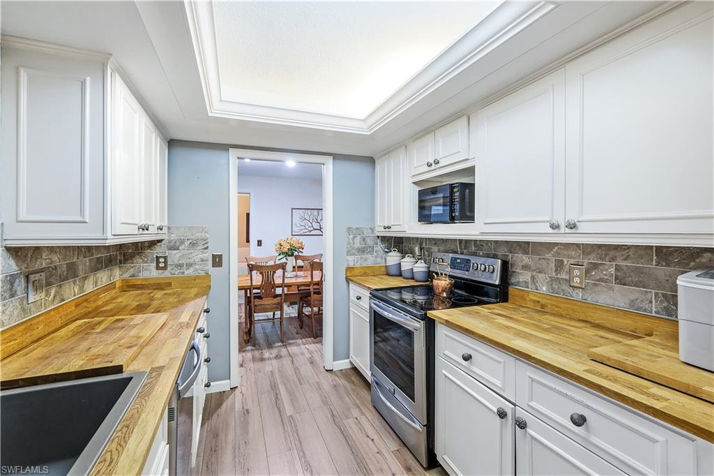 660 Pompano Drive Naples, FL 34110 - Photo 16 of 34 a kitchen with stainless steel appliances a stove sink and cabinets