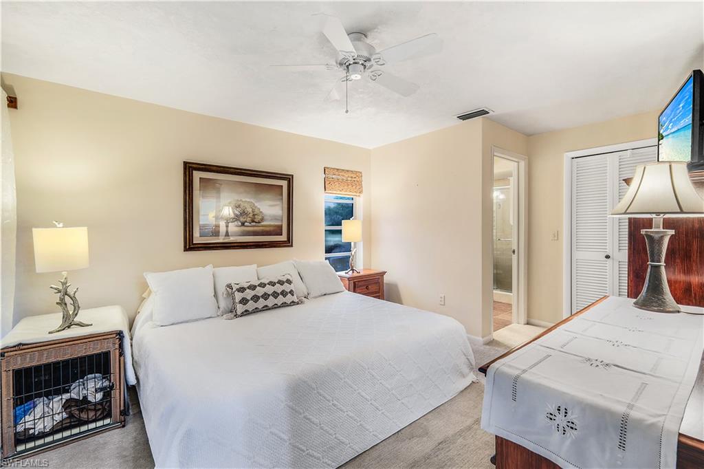 660 Pompano Drive Naples, FL 34110 - Photo 18 of 34 a bedroom with a bed and a chandelier