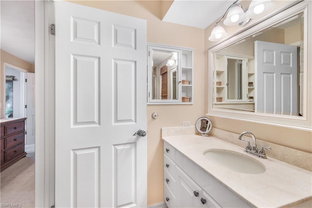 660 Pompano Drive Naples, FL 34110 - Photo 20 of 34 a bathroom with double vanity sink and a mirror