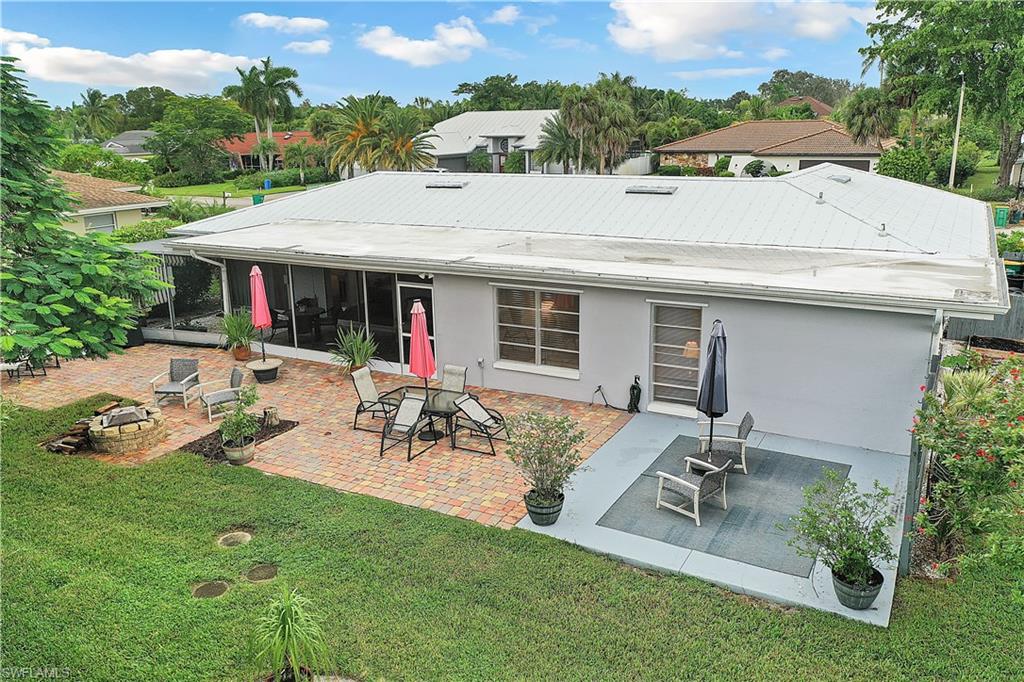 660 Pompano Drive Naples, FL 34110 - Photo 2 of 34 a view of a patio with table and chairs under an umbrella