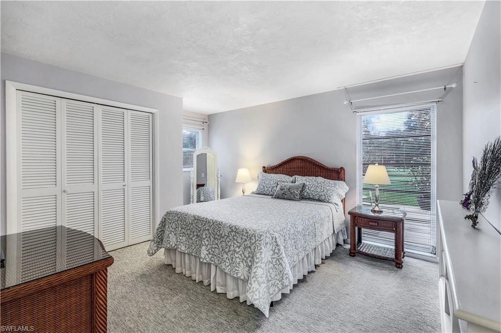 660 Pompano Drive Naples, FL 34110 - Photo 22 of 34 a spacious bedroom with a bed and a cabinets
