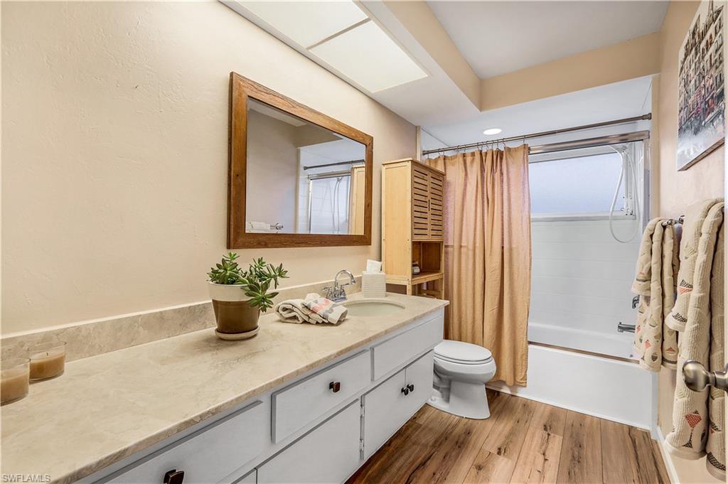 660 Pompano Drive Naples, FL 34110 - Photo 24 of 34 a bathroom with a sink a toilet a mirror and shower