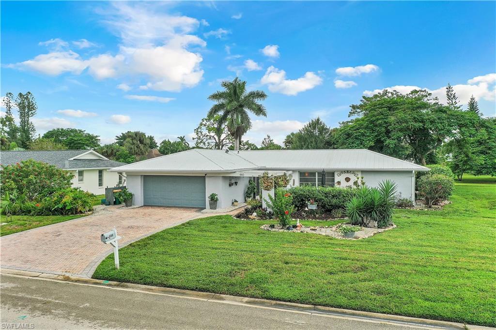 660 Pompano Drive Naples, FL 34110 - Photo 29 of 34 a front view of a house with a garden