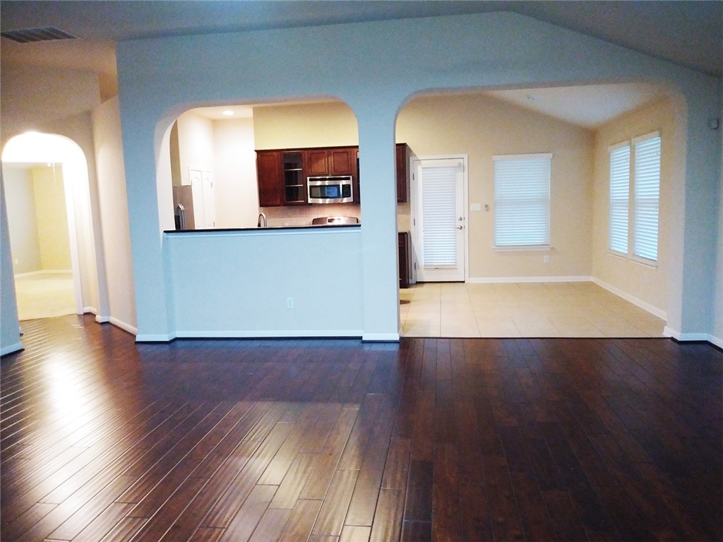 348 Stone View Trail Austin, TX 78737 - Photo 5 of 26 The huge living room has a bar pass through to the kitchen and a lovely rounded arch entry into the dining room