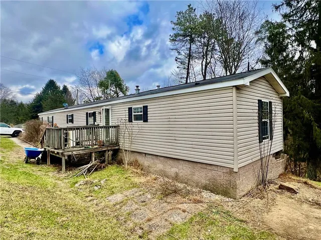 a view of a house with a yard and wooden deck