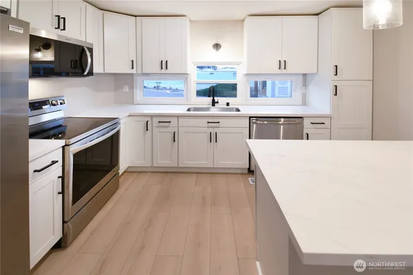 a kitchen with a sink a stove and cabinets