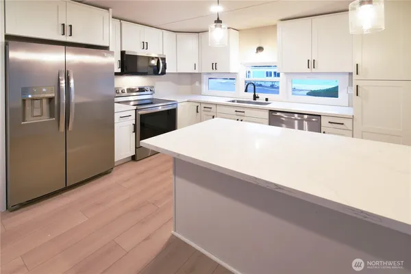 a kitchen with stainless steel appliances a refrigerator and a stove top oven