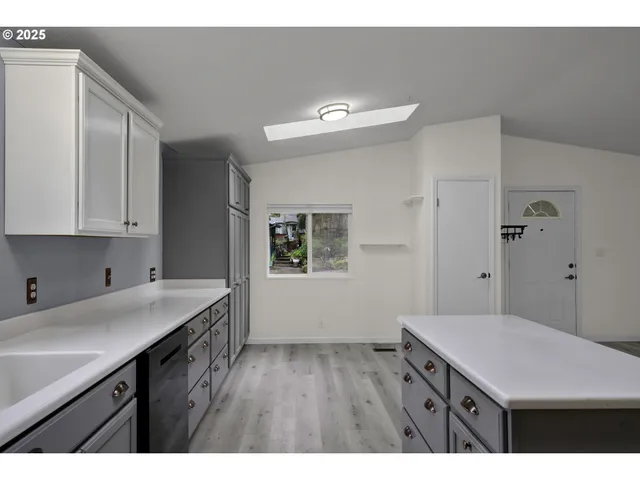 a kitchen that has a sink and a wooden floor