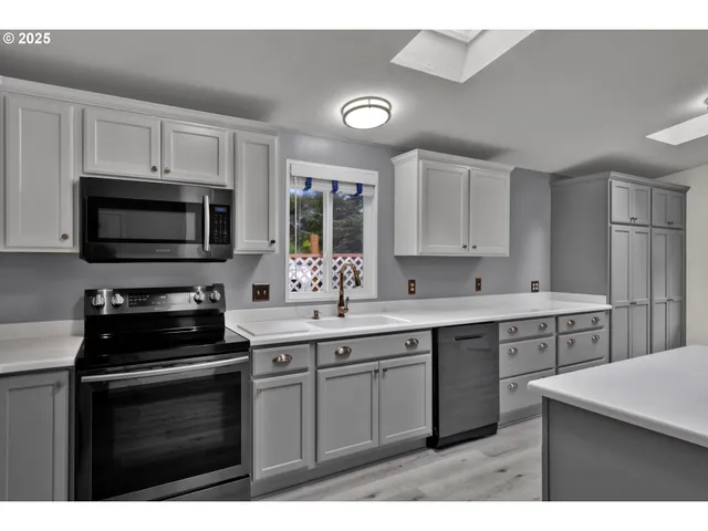 a kitchen with a sink stove and microwave