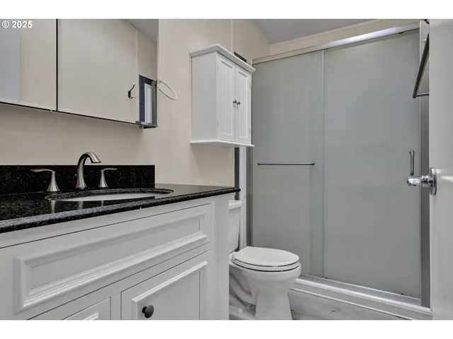 a bathroom with a sink a toilet and shower