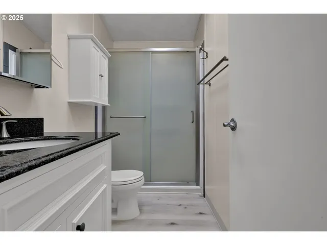 a bathroom with a granite countertop sink toilet and shower