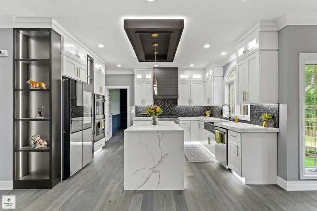 a large white kitchen with lots of counter space and stainless steel appliances