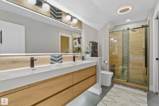 a bathroom with a double vanity sink toilet and shower