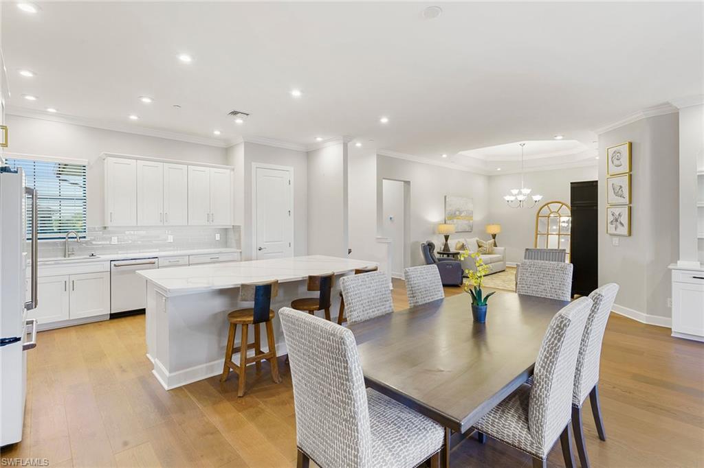 9633 Montelanico Loop, Unit 203 Naples, FL 34119 - Photo 11 of 33 a kitchen with a dining table chairs and view living room