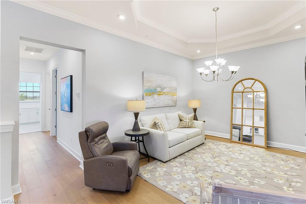 9633 Montelanico Loop, Unit 203 Naples, FL 34119 - Photo 13 of 33 a spacious bedroom with bed couches and chandelier