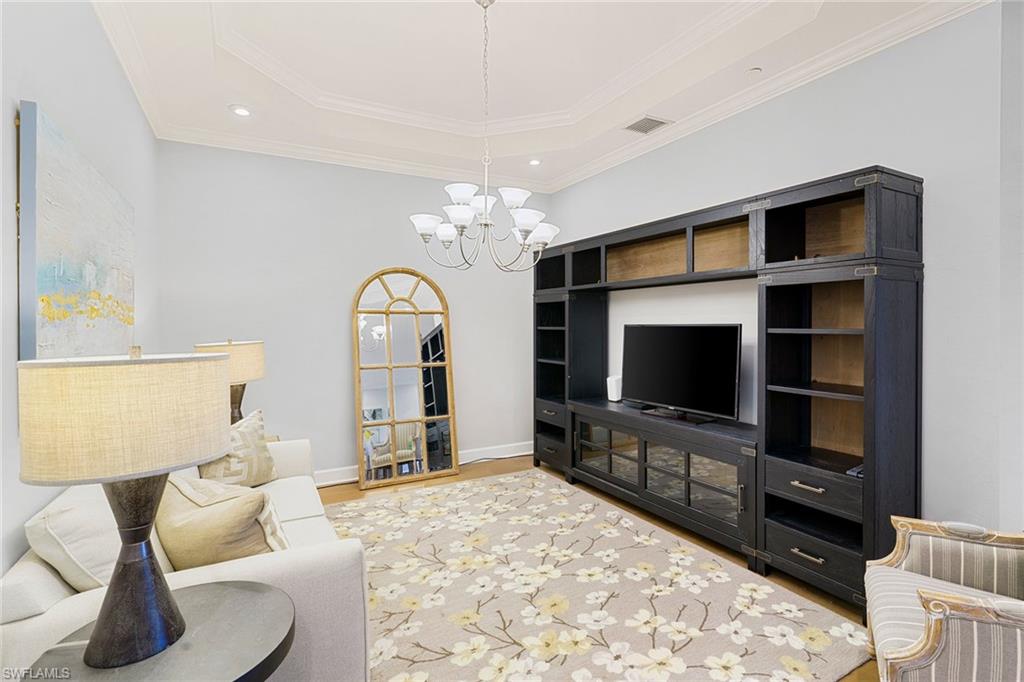 9633 Montelanico Loop, Unit 203 Naples, FL 34119 - Photo 14 of 33 a living room with furniture and a flat screen tv