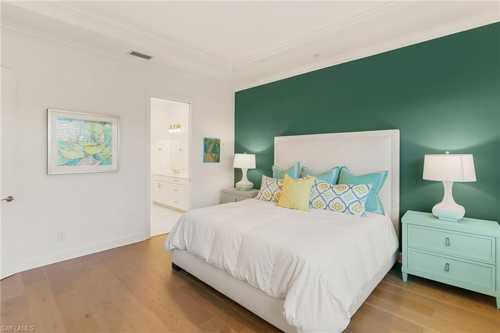 9633 Montelanico Loop, Unit 203 Naples, FL 34119 - Photo 16 of 33 a bedroom with a bed and a potted plant