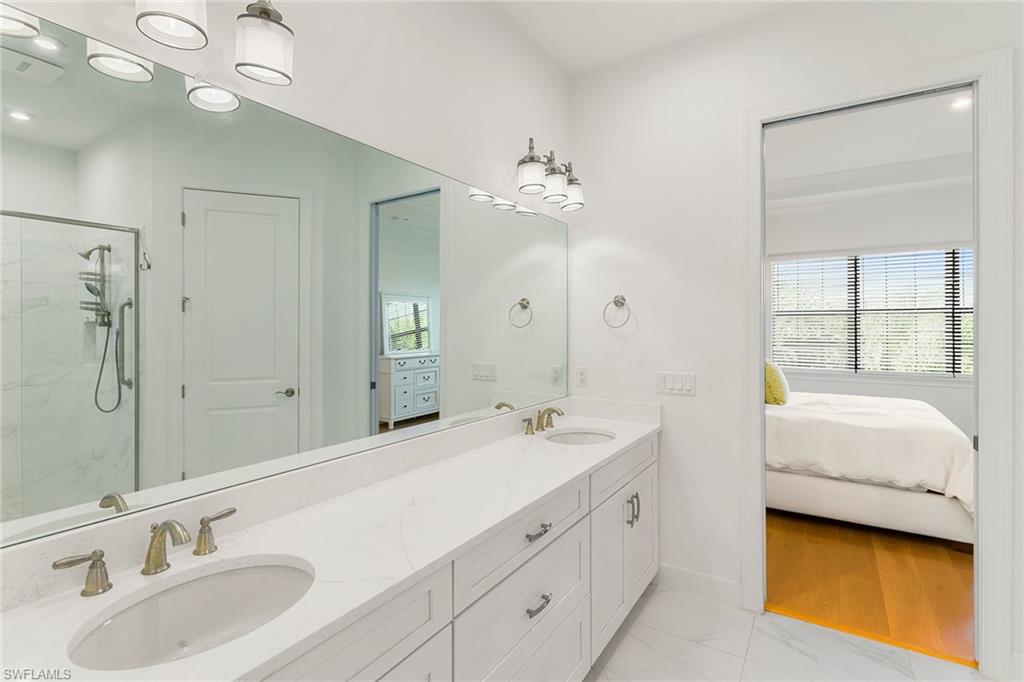 9633 Montelanico Loop, Unit 203 Naples, FL 34119 - Photo 17 of 33 a spacious bathroom with a double vanity sink mirror and double
