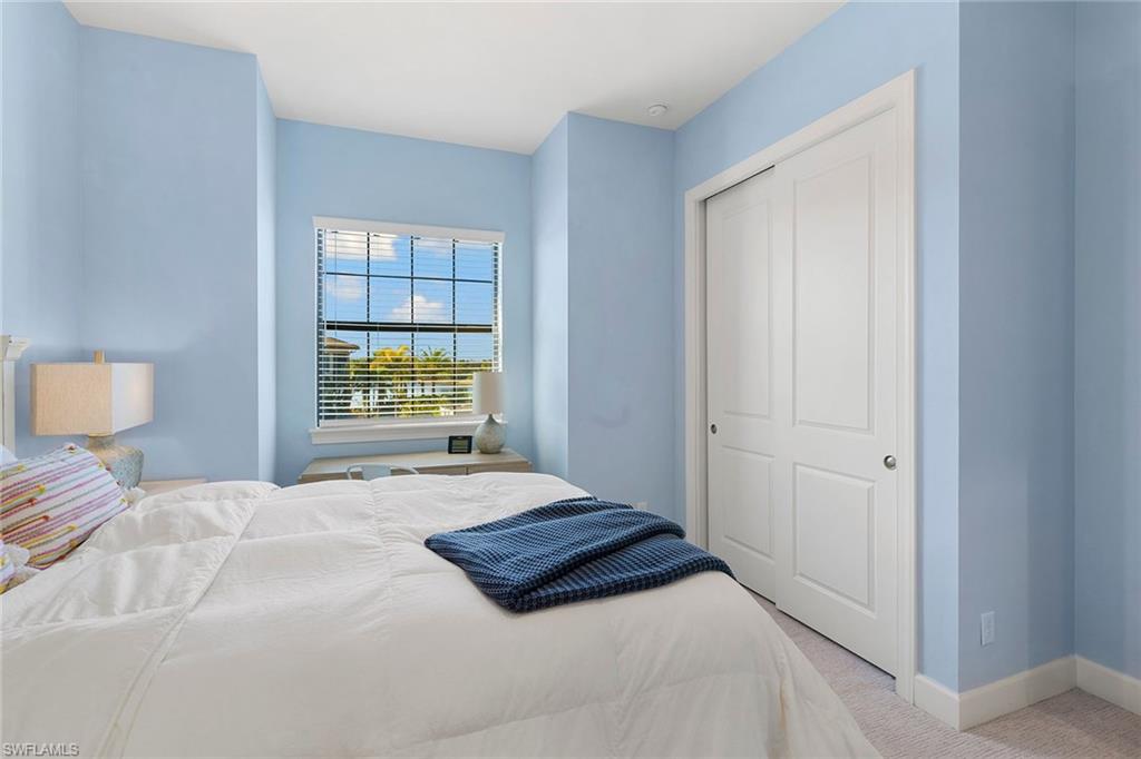 9633 Montelanico Loop, Unit 203 Naples, FL 34119 - Photo 22 of 33 a bedroom with a bed and a window