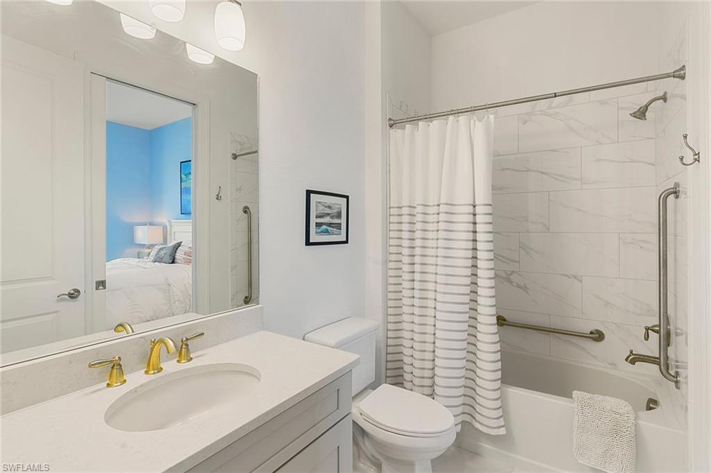 9633 Montelanico Loop, Unit 203 Naples, FL 34119 - Photo 23 of 33 a bathroom with a sink toilet and shower