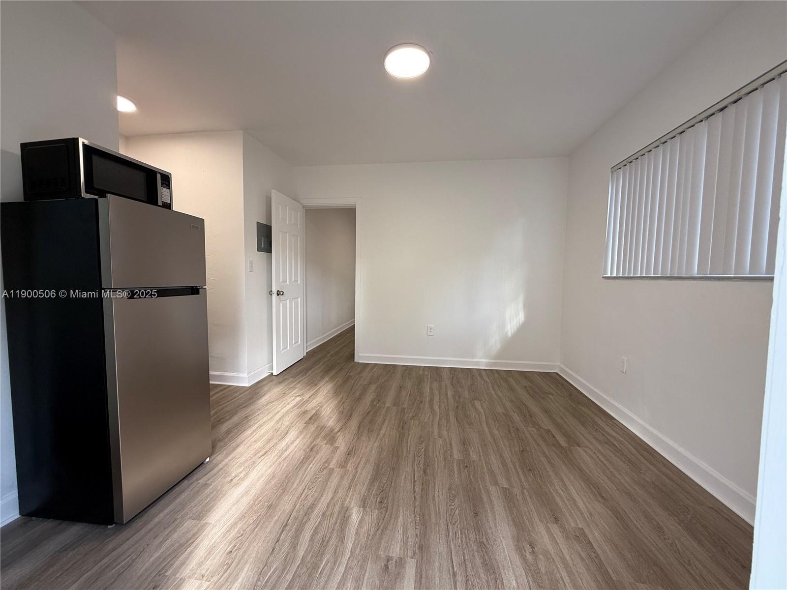 1120 Northwest 32nd Court, Unit BACK Miami, FL 33125 - Photo 2 of 10 a view of empty room with wooden floor and electronic appliances