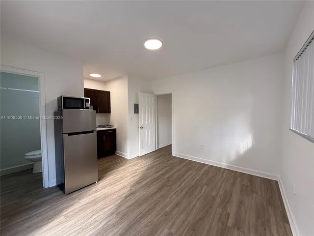 a view of kitchen with a sink refrigerator and wooden floor