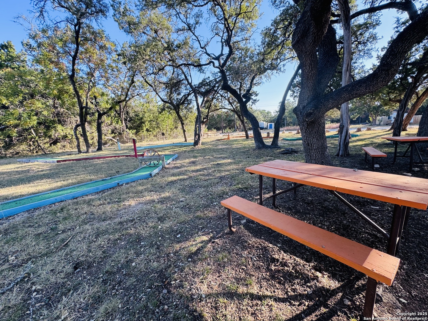 205 Center Point Road Bandera, TX 78003 - Photo 24 of 25 a backyard of a house with wooden fence and trees