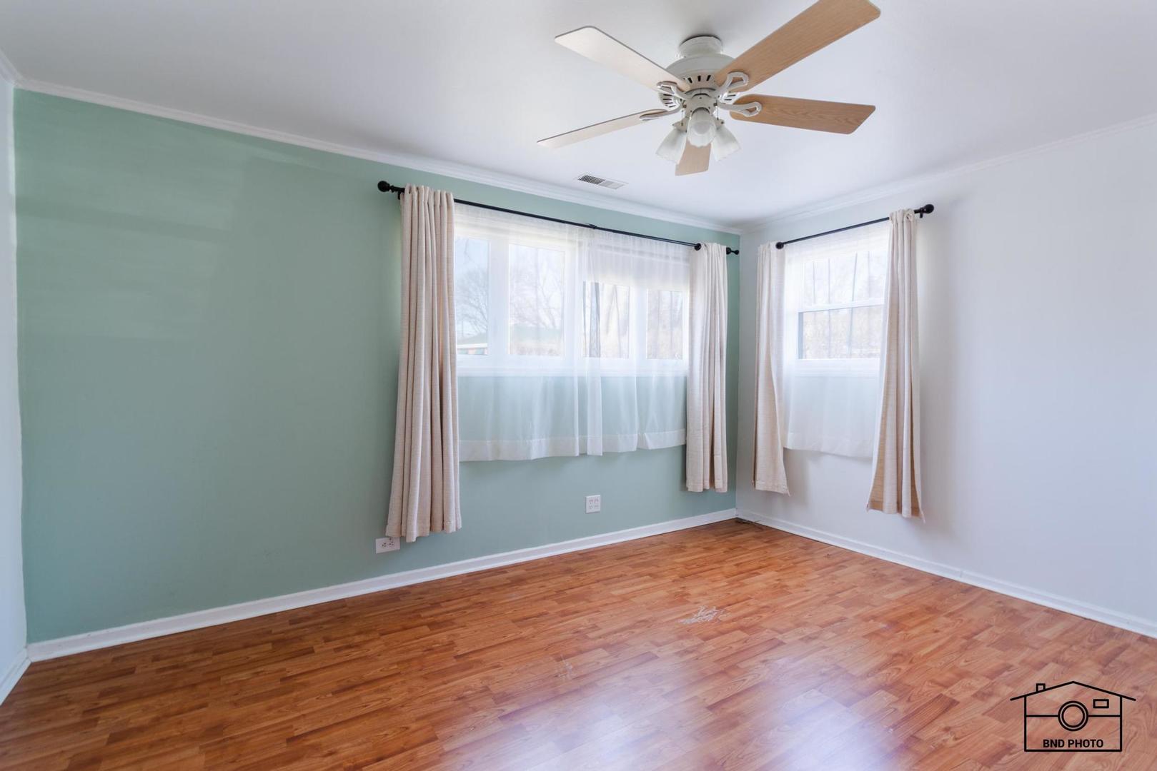 17617 Washington Avenue Homewood, IL 60430 - Photo 4 of 16 an empty room with wooden floor and windows