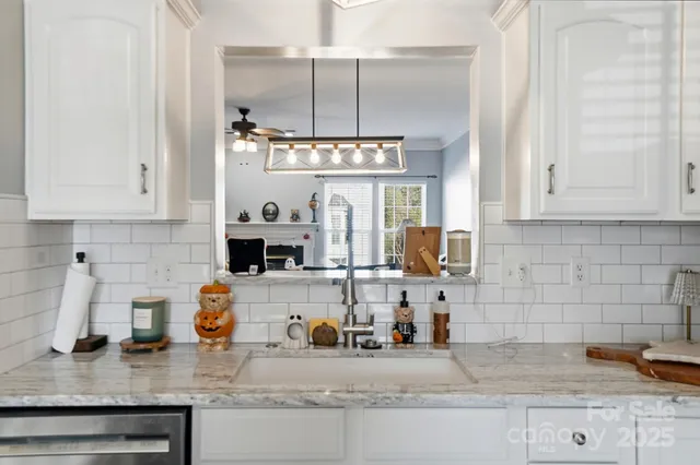 a view of a dining room and livingroom with furniture wooden floor a chandelier