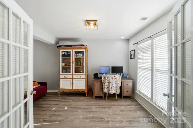 a view of a hardwood floor and windows in a room