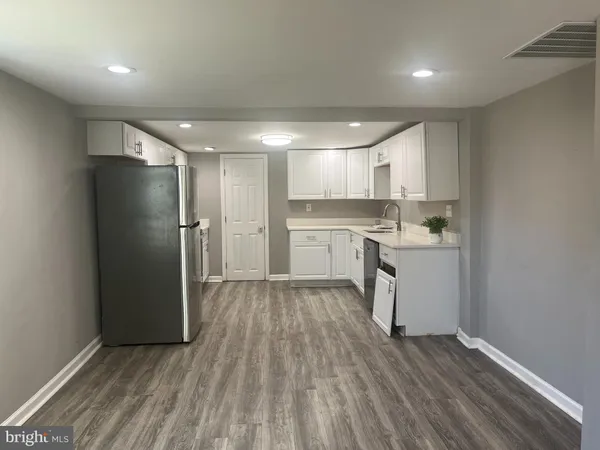 a kitchen with a refrigerator a sink and dishwasher with wooden floor