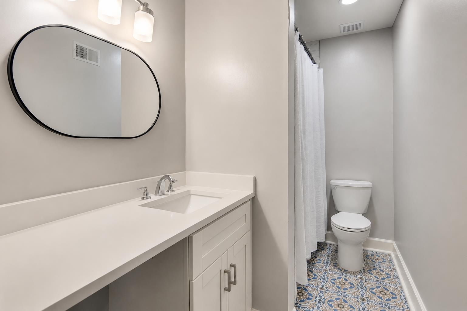 2978 Ruffle Drive Bartlett, TN 38134 - Photo 10 of 12 Bathroom featuring a white vanity with an integrated sink, polished chrome faucet, and an oval black-framed mirror