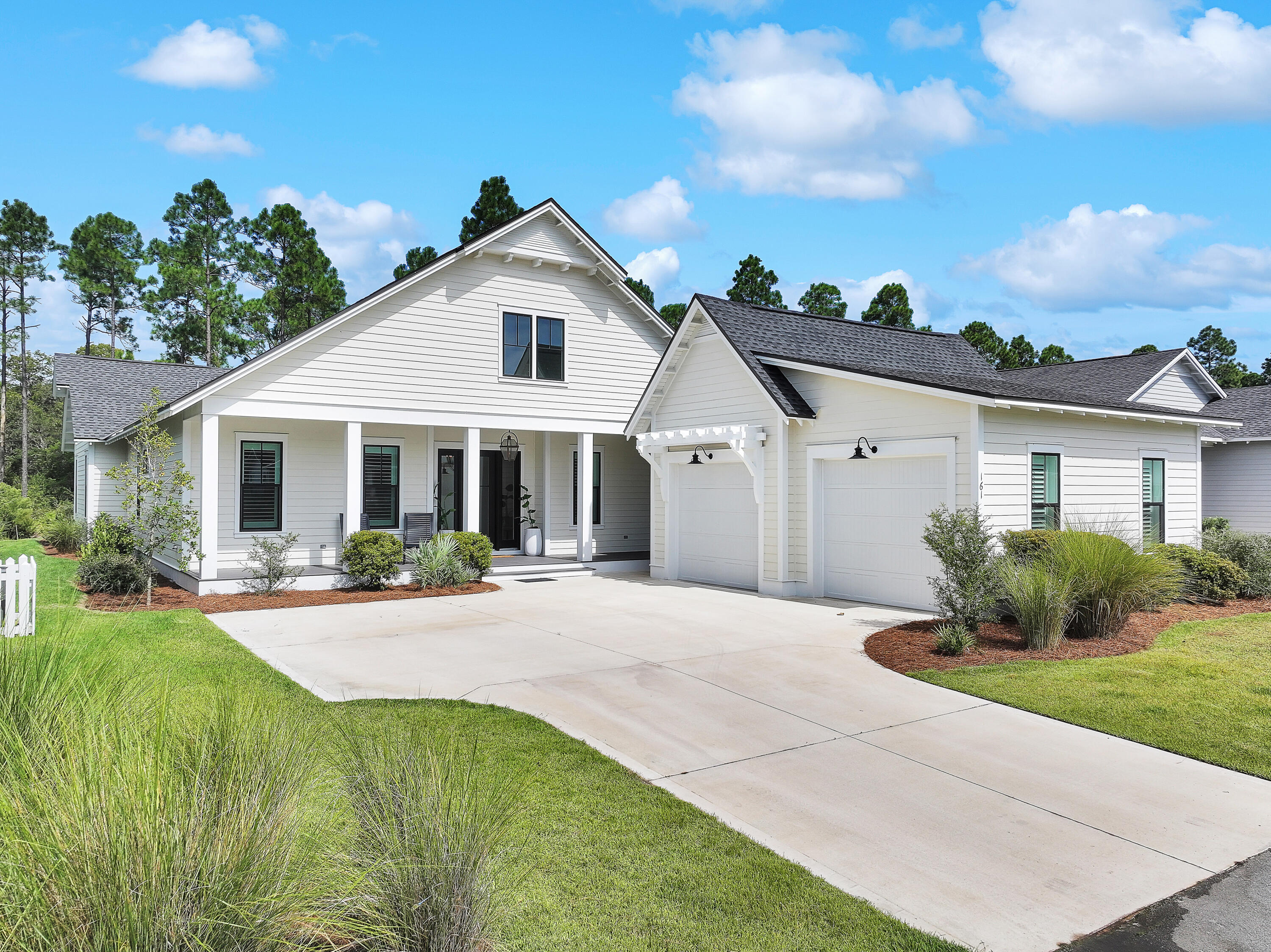 a front view of a house with a yard and potted plants