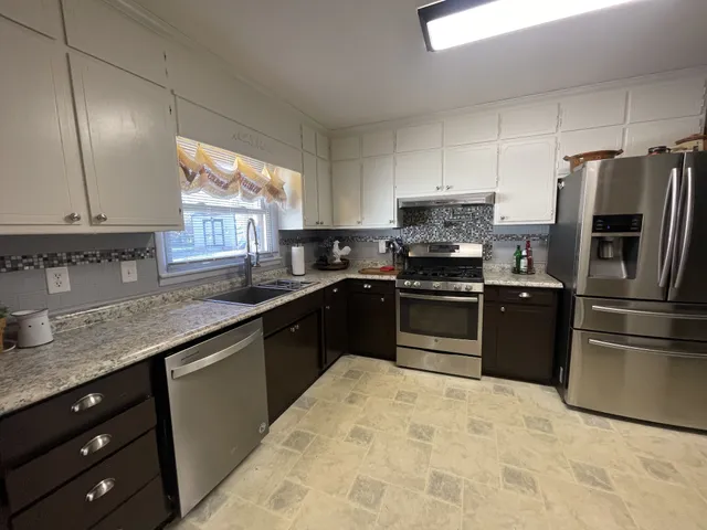 a kitchen with granite countertop a refrigerator and a sink