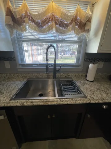 a kitchen with a sink a stove and cabinets