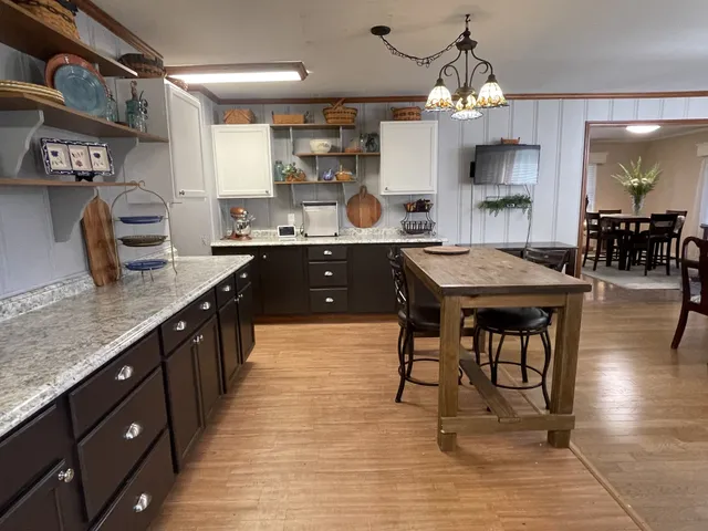 a large kitchen with granite countertop lots of counter top space and stainless steel appliances