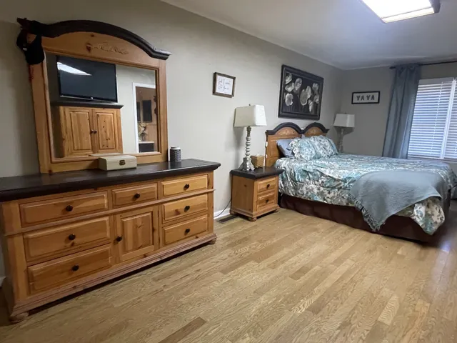 a spacious bedroom with a bed and a dresser