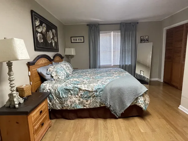 a bedroom with a bed and wooden floor