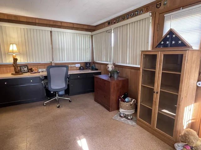 a view of a workspace with furniture and a window