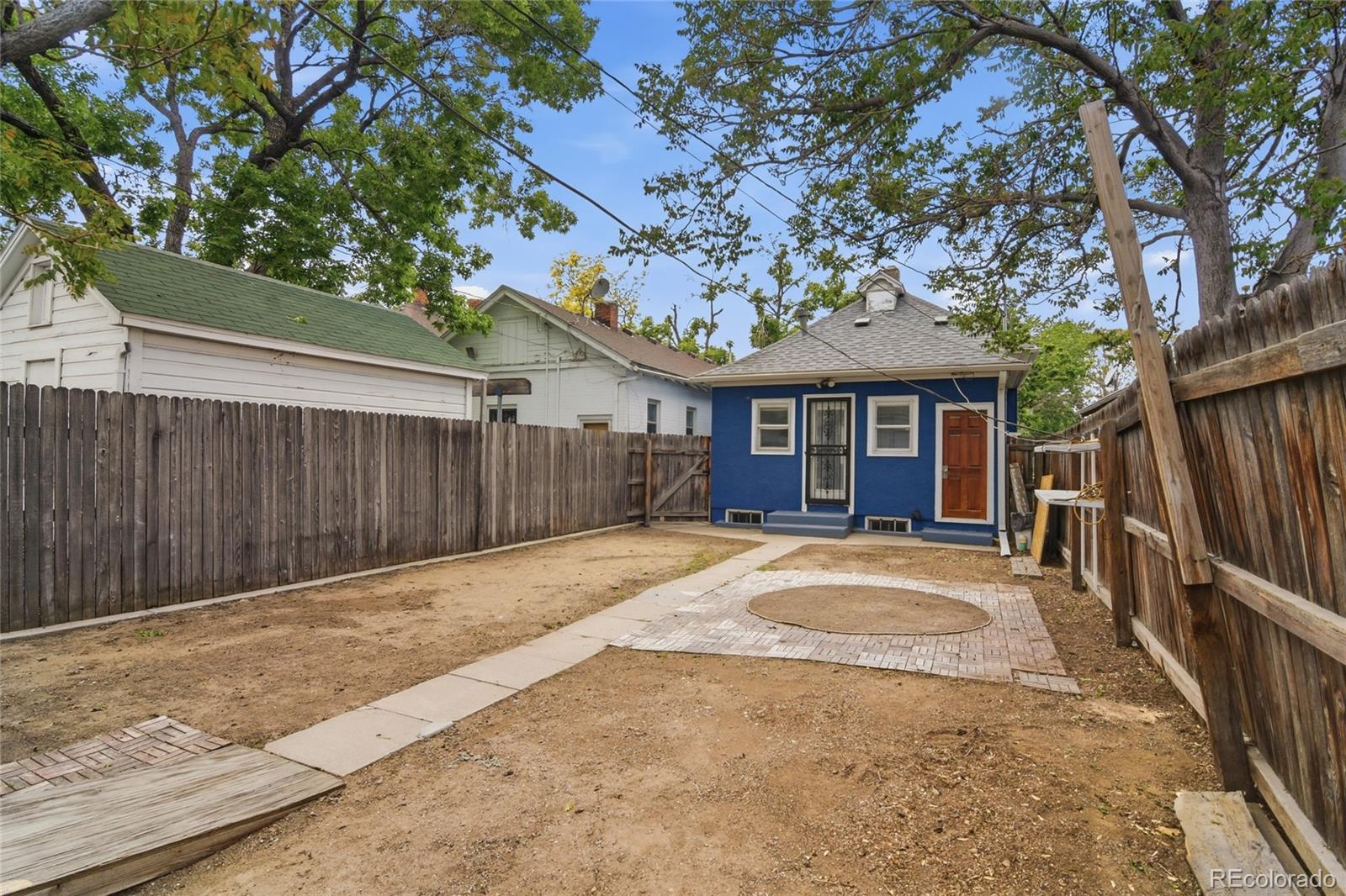 4424 Sherman Street Denver, CO 80216 - Photo 13 of 16 a front view of a house with a yard and garage