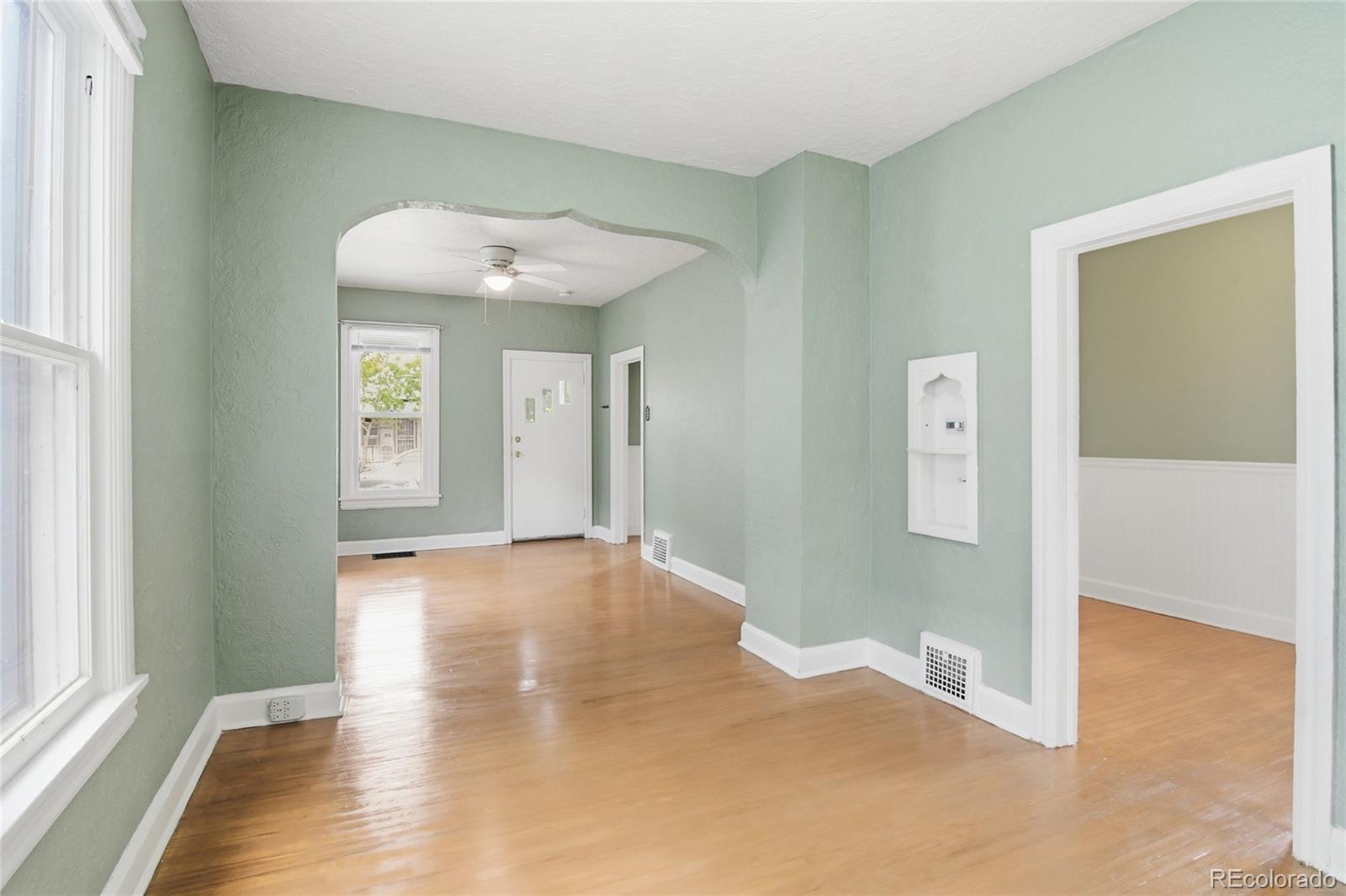 4424 Sherman Street Denver, CO 80216 - Photo 5 of 16 an empty room with wooden floor and windows