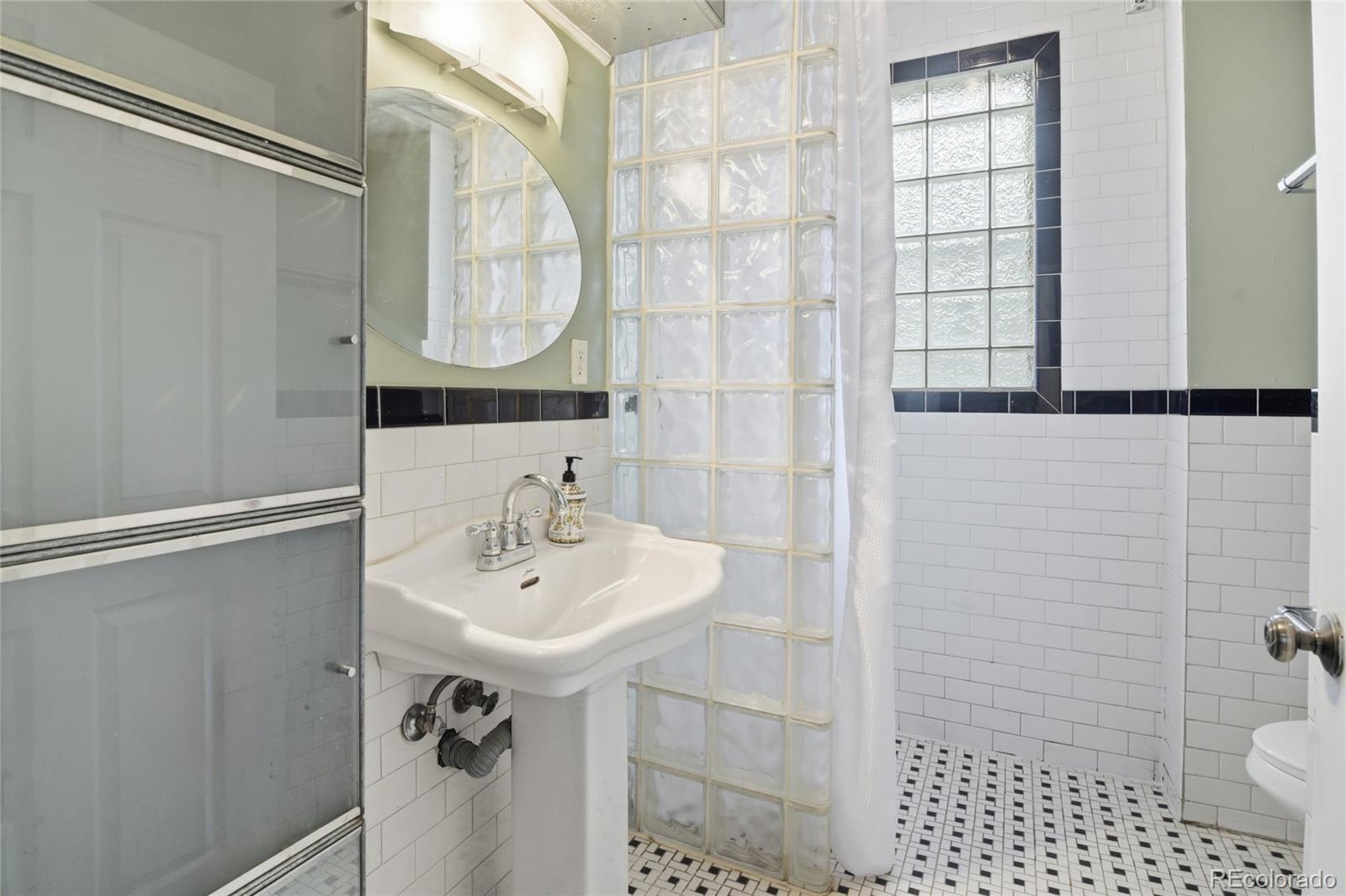 4424 Sherman Street Denver, CO 80216 - Photo 8 of 16 a bathroom with a sink toilet and shower